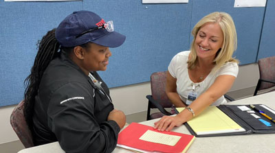 Two women sitting in a conference room working together at a table